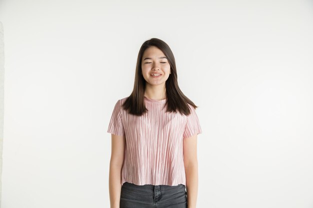 Retrato de menina linda com metade do corpo isolado na parede branca do estúdio