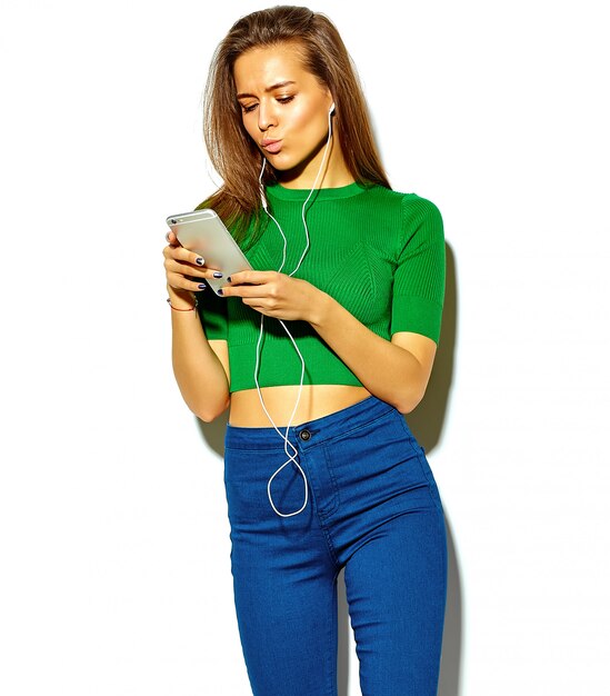 retrato de menina linda feliz morena mulher bonita em roupas de verão casual hipster verde sem maquiagem isolada no branco usando um telefone inteligente