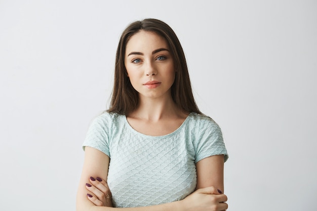 Retrato de menina morena linda com braços cruzados.