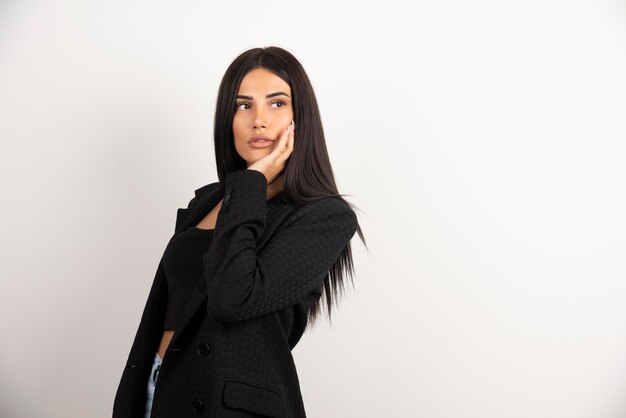 Retrato de menina morena olhando para o lado dela em fundo branco. Foto de alta qualidade