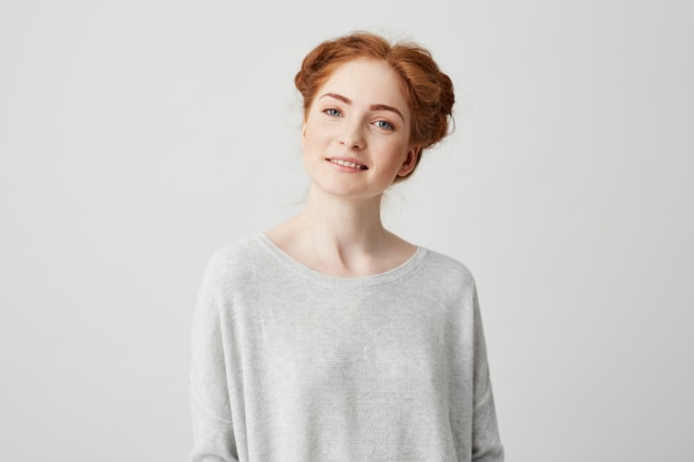 Foto grátis retrato de menina ruiva linda com pãezinhos e sardas sorrindo.