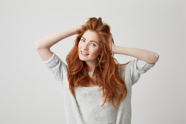 Retrato de menina ruiva linda jovem feliz, sorrindo, tocar no cabelo.