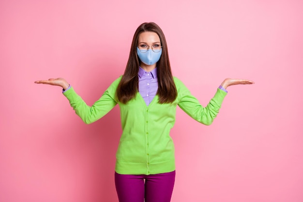 Retrato de menina segurando a mão copyspace corona vírus anúncios usam máscara médica isolada cor de fundo rosa