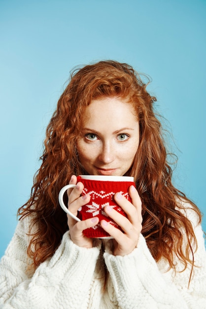 Retrato de menina sorridente bebendo chá quente