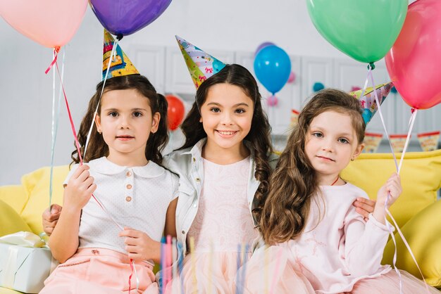 Retrato, de, meninas, sentar sofá, com, balões coloridos