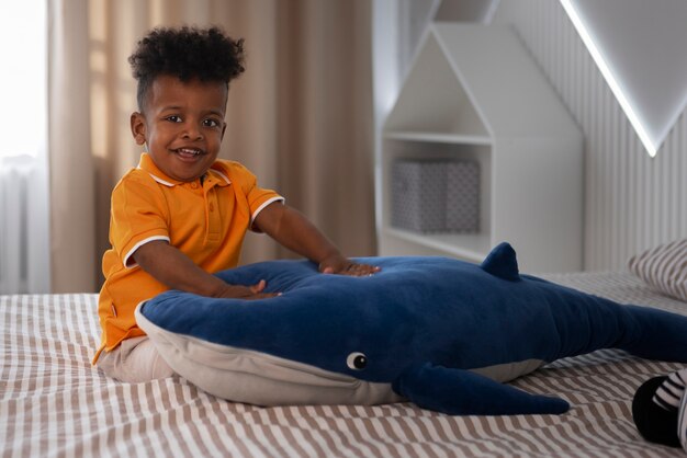 Foto grátis retrato de menino brincando com seu brinquedo de pelúcia