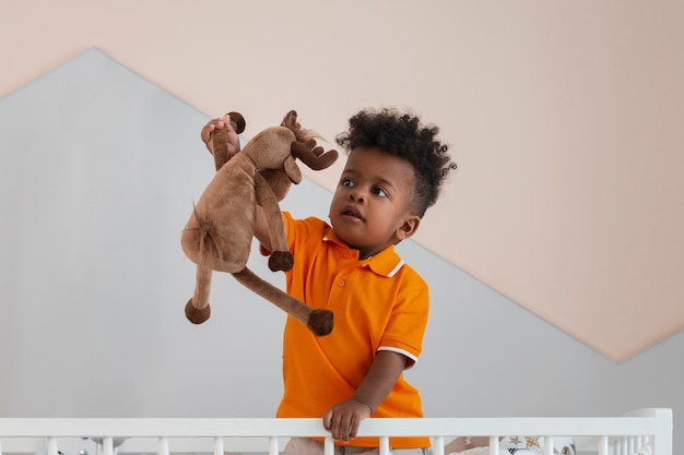 Foto grátis retrato de menino brincando com seu brinquedo de pelúcia