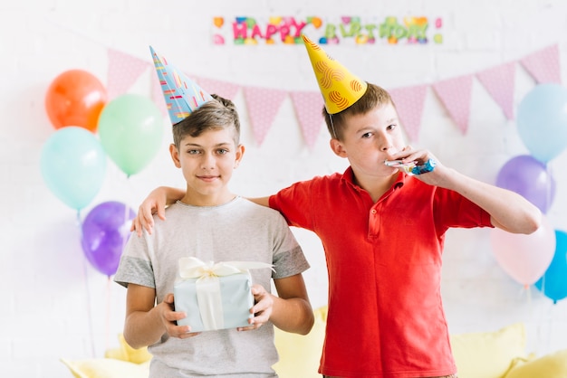 Retrato, de, menino, com, seu, amigo, segurando, presente aniversário