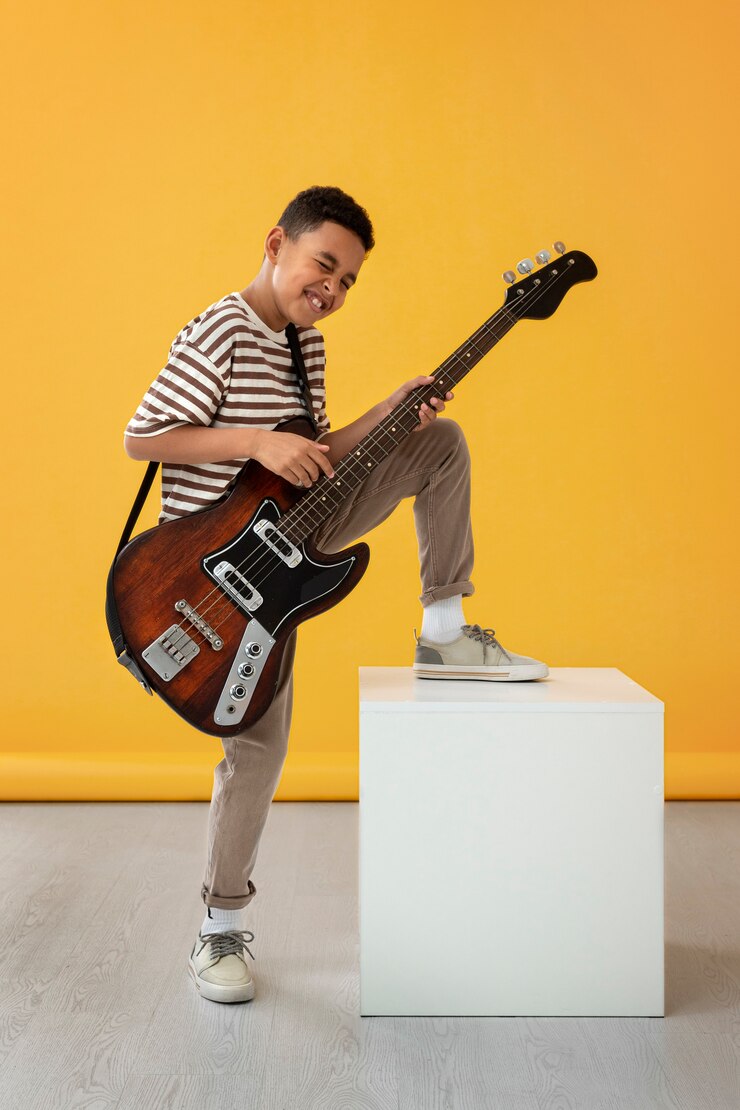 Foto grátis retrato de menino com violão