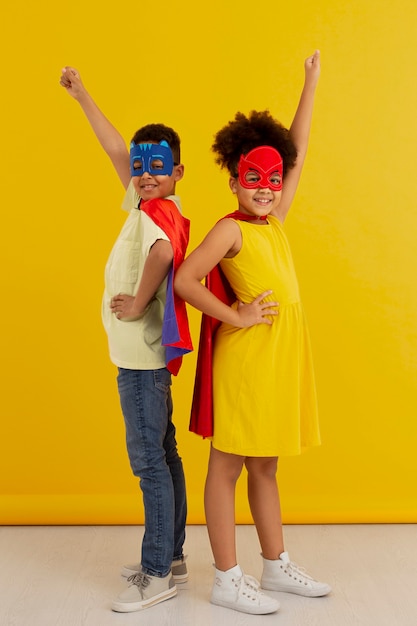 Retrato de menino e menina com capas de super-heróis