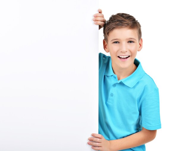 Foto grátis retrato de menino sorridente olhando para um cartaz branco isolado no branco