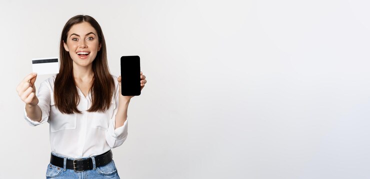 Foto grátis retrato de modelo feminino mostrando cartão de crédito com tela de smartphone recomendando aplicativo sobre fundo branco