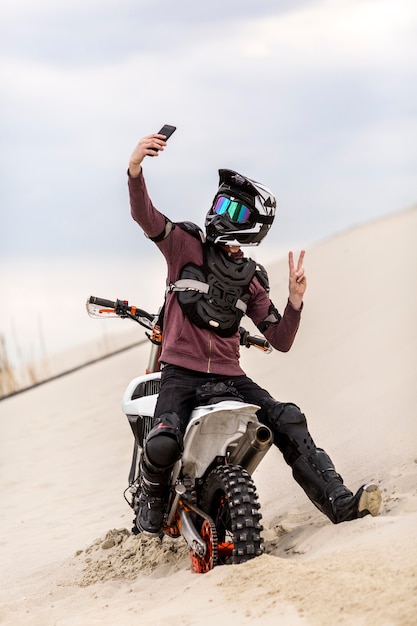 Retrato de motociclista tomando uma selfie no deserto