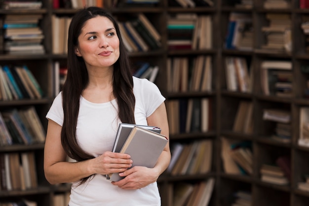 Retrato de mulher adulta segurando livros