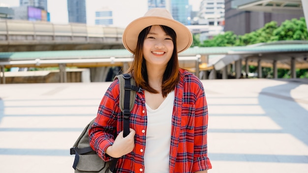 Retrato de mulher asiática sorridente jovem e atraente ao ar livre na cidade