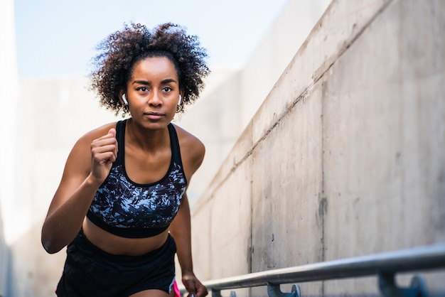 Retrato de mulher atleta afro correndo e fazendo exercícios ao ar livre