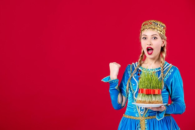 Retrato de mulher azeri em vestido tradicional, segurando o estúdio semeni filmado na primavera étnica de novruz de fundo vermelho