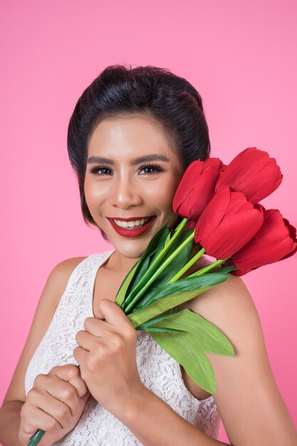 Retrato de mulher bonita com buquê de flores tulipa vermelha