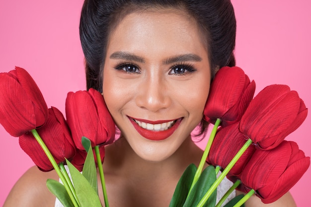 Retrato de mulher bonita com buquê de flores tulipa vermelha