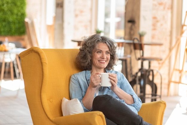 Foto grátis retrato de mulher bonita desfrutando de uma xícara de café