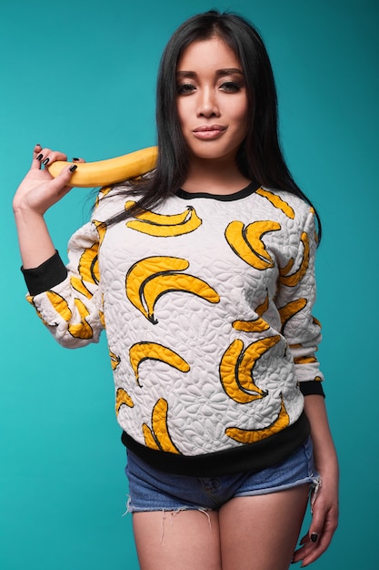 Retrato de mulher bonita e elegante camisola com padrão de banana