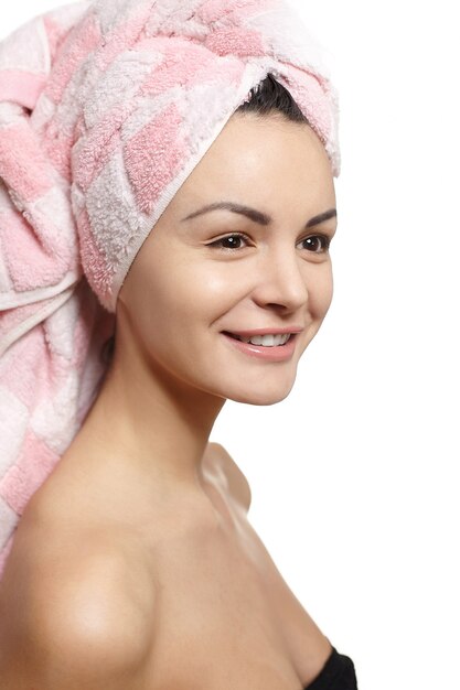 retrato de mulher bonita e sorridente caucasiano em toalha na cabeça isolada no estúdio branco