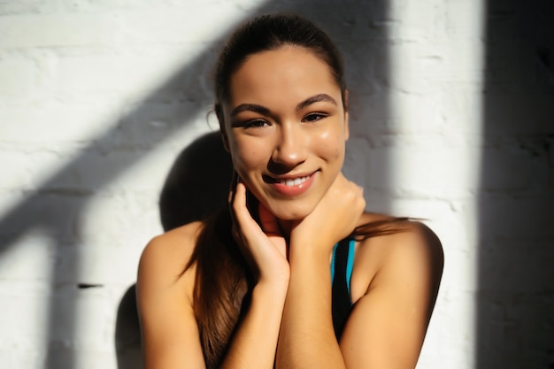 Retrato de mulher bonita. Garota feliz em forma em roupas esportivas rindo