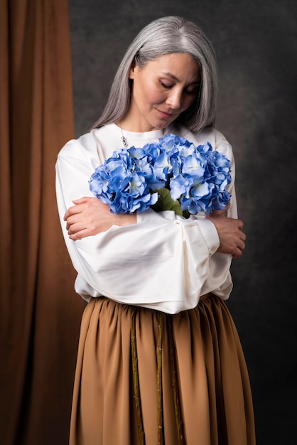 Retrato de mulher bonita sênior com buquê de flores