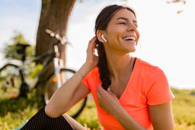 Retrato de mulher bonita sorridente fazendo esportes de manhã no parque