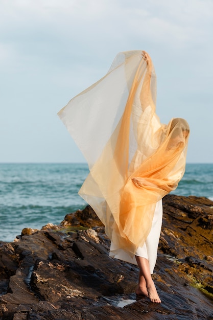 Foto grátis retrato de mulher cobrindo o rosto com véu na praia