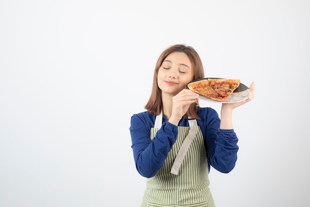 Retrato de mulher com avental de cozinha segurando um prato de pizza em branco