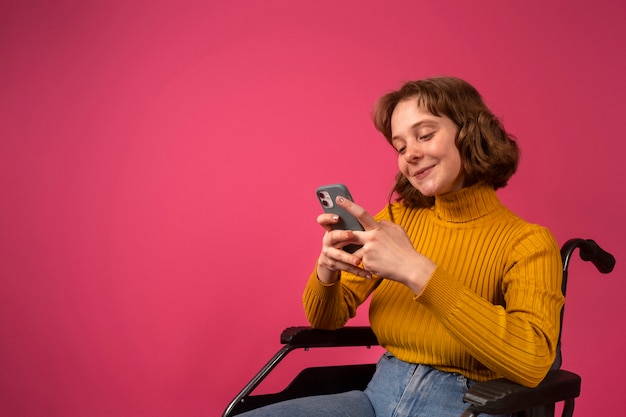 Retrato de mulher com deficiência em cadeira de rodas com smartphone