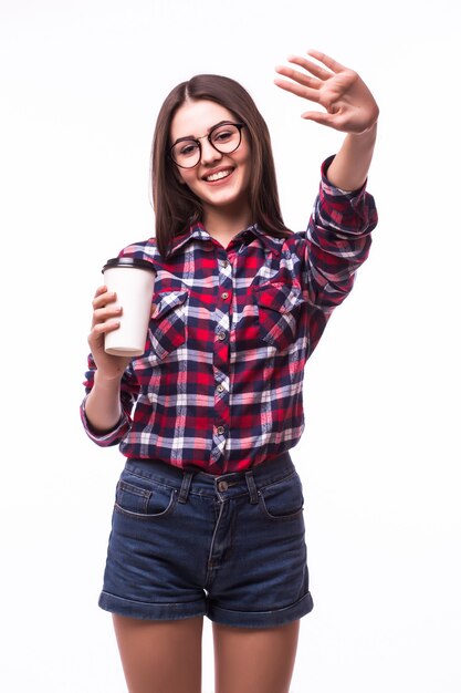 Retrato de mulher com gesto de Olá, beber chá ou café de copo de papel em branco.