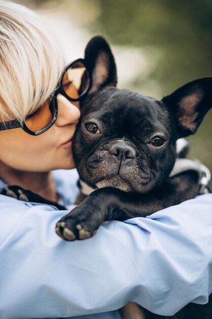 Retrato de mulher com seu bulldog francês de estimação em um parque