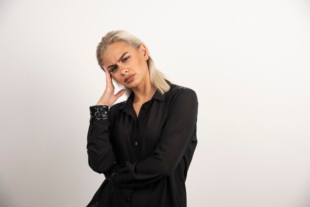 Retrato de mulher de camisa preta, posando em fundo branco. Foto de alta qualidade