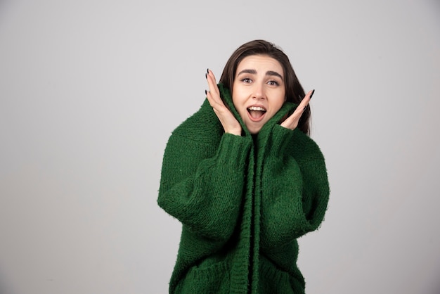 Retrato de mulher de casaco verde, sentindo-se feliz.