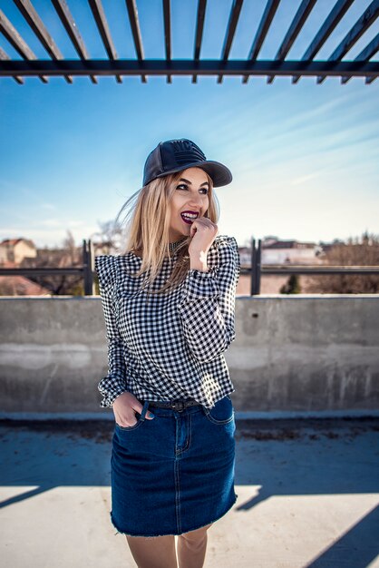 Retrato de mulher de moda vestindo camisa de xadrez e boné de couro