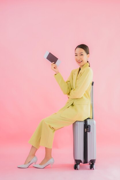 Retrato de mulher de negócios asiática jovem bonita com bolsa de bagagem e passaporte em cores