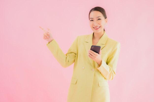 Retrato de mulher de negócios jovem asiática usando telefone celular inteligente com xícara de café na cor