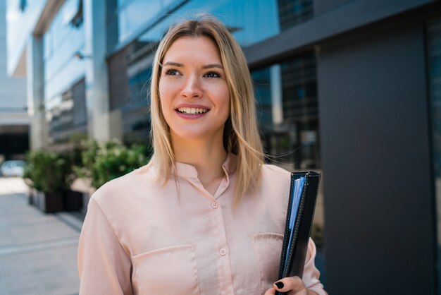 Retrato de mulher de negócios jovem do lado de fora de edifícios de escritórios. Conceito de negócios e sucesso.