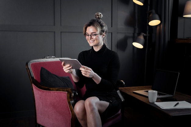 Foto grátis retrato de mulher de negócios verificando um tablet