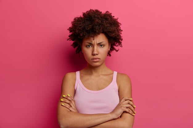 Retrato de mulher de pele morena insatisfeita e insatisfeita cruza os braços sobre o corpo, olha com desprazer, sorri e expressa atitude negativa, conversa desagradável com o marido após briga.