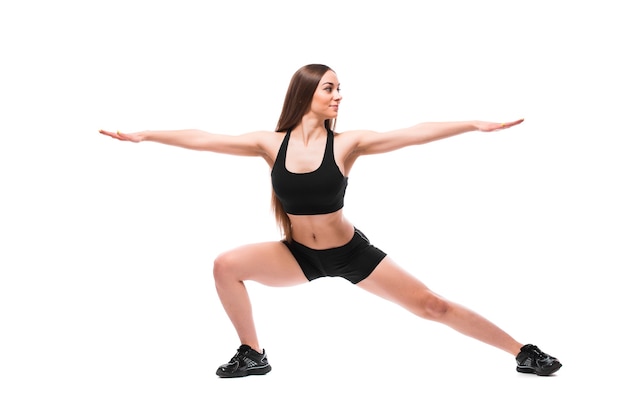 Retrato de mulher desportiva em roupas esportivas, malhando, fazendo exercícios isolados no fundo branco