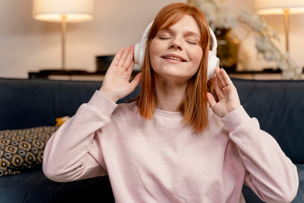 Foto grátis retrato de mulher em casa ouvindo música