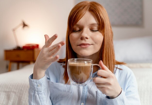 Retrato de mulher em casa tomando café