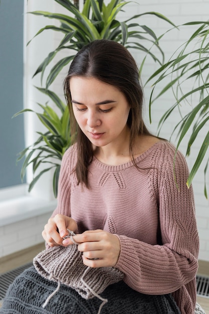 Retrato de mulher em casa tricotando