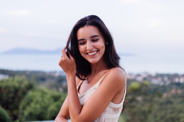 Retrato de mulher feliz caucasiana calma romântica em look casual com cabelo comprido usando brincos e colar no fundo incrível bela vista nas montanhas verdes