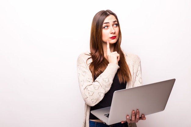 Foto grátis retrato de mulher feliz e surpresa em pé com laptop cinza