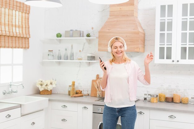 Retrato de mulher feliz sênior com fones de ouvido