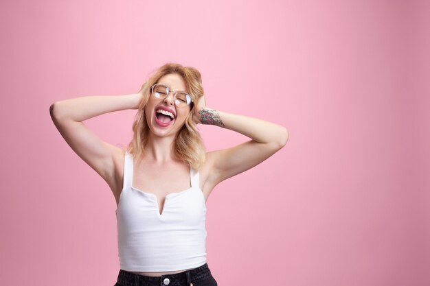 Retrato de mulher jovem caucasiano isolado no estúdio rosa